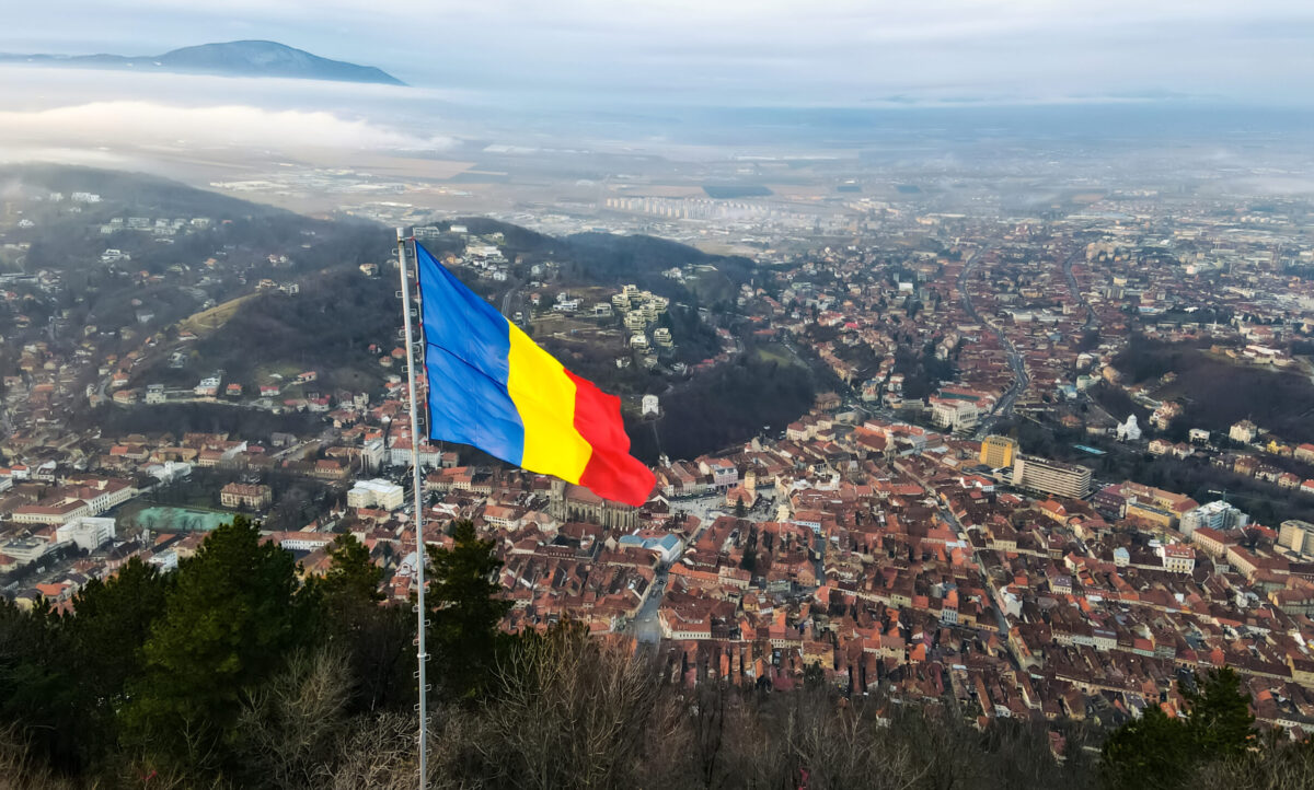 National flag on the top of a hill near Barsov, bare trees, low clouds, cityscape, Romania